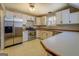 Well-lit kitchen featuring stainless steel appliances, light countertops, and white cabinetry at 787 N Ola Rd, Mcdonough, GA 30252