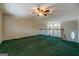 Spacious living room featuring green carpeting and a ceiling fan for added comfort at 787 N Ola Rd, Mcdonough, GA 30252