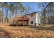 Rear exterior view of house with deck and large wooded lot at 787 N Ola Rd, Mcdonough, GA 30252