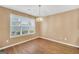 Light-filled dining room with wood-look floors, modern chandelier, and large window at 11531 E Lovejoy Rd, Hampton, GA 30228