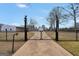 Grand gated entrance featuring automatic gate, decorative lighting, and secure access to a private estate at 11531 E Lovejoy Rd, Hampton, GA 30228