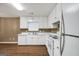 Bright kitchen featuring white appliances, cabinets, and modern countertops with wood-look floors at 11531 E Lovejoy Rd, Hampton, GA 30228