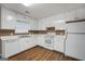 Bright kitchen featuring white appliances, cabinets, and modern countertops with wood-look floors at 11531 E Lovejoy Rd, Hampton, GA 30228