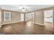 Comfortable living room showcasing wood floors, neutral paint, and access to the kitchen and other rooms at 11531 E Lovejoy Rd, Hampton, GA 30228