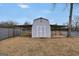 Backyard shed with awning featuring a white cross-buck door and lattice detailing in a large, grassy yard at 11531 E Lovejoy Rd, Hampton, GA 30228
