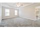 Large bedroom with neutral carpet, a ceiling fan, and windows at 3167 Sw Clairide Dr, Conyers, GA 30094