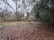 Large, leaf-covered backyard with a playset visible in the distance at 392 Carey Se Dr, Atlanta, GA 30315