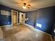 Blue painted bedroom with carpet floors, ceiling fan, and closet access at 392 Carey Se Dr, Atlanta, GA 30315