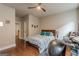 Bedroom with hardwood floors, a ceiling fan, and a bed with decorative pillows, plus an adjacent workstation at 3157 Oakdale Rd, Hapeville, GA 30354