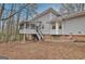 Back of house featuring a screened porch and a backyard with pine needles on the ground at 200 Deer Forest Trl, Fayetteville, GA 30214