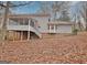 Back of house featuring a screened porch and a backyard covered in fallen leaves at 200 Deer Forest Trl, Fayetteville, GA 30214