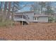 Back of house featuring a screened porch and a backyard covered in fallen leaves at 200 Deer Forest Trl, Fayetteville, GA 30214