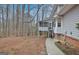 View of the backyard featuring a screened porch with steps and a partially wooded lot at 200 Deer Forest Trl, Fayetteville, GA 30214