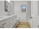 Bright bathroom featuring a sleek white vanity, a square mirror and wood-look flooring at 200 Deer Forest Trl, Fayetteville, GA 30214