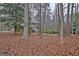 View of the brick home from a distance through a wooded lot at 200 Deer Forest Trl, Fayetteville, GA 30214