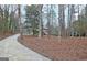 View of the home through the trees along a concrete driveway in a wooded lot at 200 Deer Forest Trl, Fayetteville, GA 30214