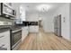 Bright kitchen showcasing stainless steel appliances, white cabinetry, and attractive wood-look flooring at 200 Deer Forest Trl, Fayetteville, GA 30214