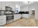 Well-lit kitchen featuring stainless steel appliances, white cabinets, and wood-look flooring at 200 Deer Forest Trl, Fayetteville, GA 30214