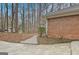 Brick side exterior of the house, surrounded by wooded area and concrete path at 200 Deer Forest Trl, Fayetteville, GA 30214