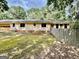 Back exterior of a home, with attached garage, mossy yard, and some fencing at 1327 Highway 54 E, Fayetteville, GA 30214