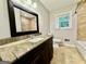 Bathroom featuring a granite countertop, dark wood vanity, tile flooring and window to allow natural light at 1327 Highway 54 E, Fayetteville, GA 30214