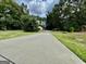 Long driveway leading to a charming home, surrounded by lush green grass and towering trees at 1327 Highway 54 E, Fayetteville, GA 30214