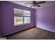 This bedroom features purple walls, carpet flooring, a ceiling fan, and a window that brings in lots of light at 3028 Hallman Cir, Marietta, GA 30064