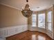 Elegant dining room with hardwood floors, wainscoting, a decorative chandelier, and bay window with natural light at 3028 Hallman Cir, Marietta, GA 30064