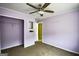 This bedroom features purple walls, carpet flooring, a ceiling fan, a closet, and a door to another room at 3028 Hallman Cir, Marietta, GA 30064