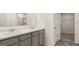 Bathroom with dual sinks, marble counters, gray cabinets, and a view to the closet at 564 Whitman Ln # 2017, Stockbridge, GA 30281
