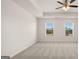 Spacious bedroom with neutral carpet, ceiling fan, and large windows at 564 Whitman Ln # 2017, Stockbridge, GA 30281
