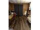 Bedroom featuring vinyl flooring and wood paneling with a rocking chair at 9055 Kelly Ct, Jonesboro, GA 30236