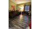 Spacious living room with dark wood-look flooring, a large window and plenty of comfortable seating at 9055 Kelly Ct, Jonesboro, GA 30236