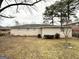 Backyard view of one-story home with light-colored exterior, mature trees, and fenced yard at 3011 Belvedere Ln, Decatur, GA 30032