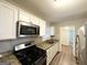 Kitchen featuring white cabinets, stainless steel appliances, and granite countertops at 3011 Belvedere Ln, Decatur, GA 30032