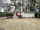Single story home with a red front door, front bushes and a front lawn at 3696 Aldea Dr, Decatur, GA 30032