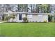 Charming single-story home featuring a well-manicured lawn and tidy landscaping at 3696 Aldea Dr, Decatur, GA 30032