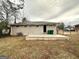 A backyard showing the back of the home with a concrete patio area and fenced yard at 3711 Tulip Dr, Decatur, GA 30032