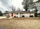 Quaint one-story home featuring a red front door, brick facade, and landscaped yard at 3711 Tulip Dr, Decatur, GA 30032