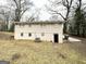 View of the backyard with trees, an air conditioner, and a black door at 105 Hillside Se Ave, Atlanta, GA 30315