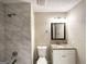 Clean bathroom featuring a stand-up shower with marble-like tile and granite vanity top at 5468 Pepperwood Ct, Stone Mountain, GA 30087