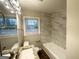 A clean, bright bathroom featuring tile, updated vanity, updated lighting, and a window for natural light at 1158 Edgefield Sw Dr, Atlanta, GA 30310