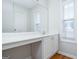 Bathroom vanity with a white countertop, mirror, storage cabinets and window at 1870 Wildcat Trace Cir, Lawrenceville, GA 30043