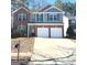 Charming two-story home featuring a brick and gray shingle facade, a well-maintained lawn, and a two-car garage at 1870 Wildcat Trace Cir, Lawrenceville, GA 30043