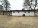 The backyard reveals a single-story home with a covered patio and an open yard surrounded by mature trees at 3507 Sage Dr, Lithia Springs, GA 30122