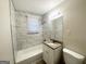 A pristine bathroom featuring marble-style tiling, a granite-topped vanity, and modern fixtures at 360 Belgarde Pl, Atlanta, GA 30354