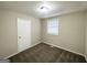 A cozy bedroom illuminated by natural light, featuring neutral walls and plush carpeting at 360 Belgarde Pl, Atlanta, GA 30354