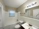 Bright bathroom with a shower-tub combo, white tiles, and a large mirror at 2174 Doris Dr, Decatur, GA 30034
