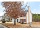 View of the two-story house with red shutters, mature trees, and a well-kept lawn at 2916 Ward Lake Way, Ellenwood, GA 30294