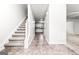 Bright foyer with staircase and tile flooring, leading to the kitchen and living area at 2916 Ward Lake Way, Ellenwood, GA 30294